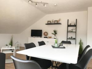 una sala de reuniones con mesa blanca y sillas en Zollernalb-Apartment, en Albstadt