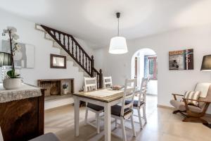a dining room with a table and chairs and a fireplace at Townhouse Lleo 72 By homevillas360 in Pollença