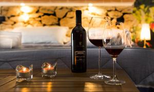 Una botella de vino y dos copas en una mesa. en Solaris B&B, en Milazzo