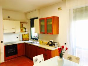 uma cozinha com armários de madeira e um balcão branco em Camere Delle Rose em Milão