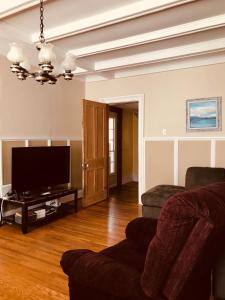 ein Wohnzimmer mit einem Sofa und einem Flachbild-TV in der Unterkunft Niagara Vacation Homes Canada in Niagara Falls