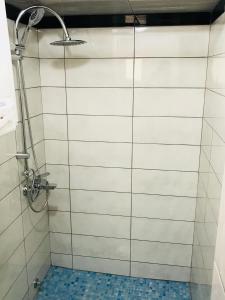 y baño con ducha y paredes de azulejos blancos. en Apartments Sunpoint, en Ulcinj