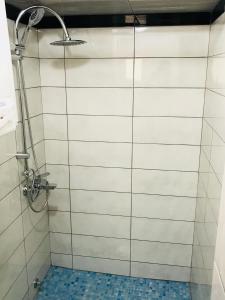 a bathroom with a shower with white tile walls at Apartments Sunpoint in Ulcinj
