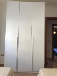 ポルト・トッレスにあるAppartamento Margóのベッド2台付きの客室内の白い大型キャビネット