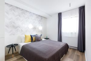 a bedroom with a bed and a large window at SWU Broadway in Budapest