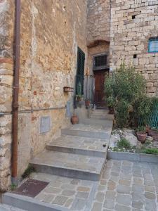 a stone building with steps leading up to a door at Casa di NELLA in Campiglia Marittima
