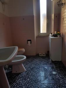 a bathroom with a sink and a toilet and a window at Casa di NELLA in Campiglia Marittima