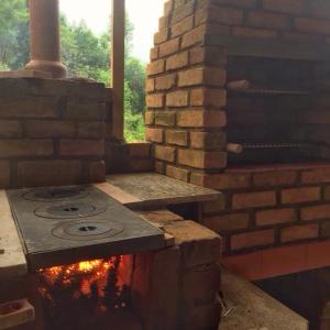 a stone oven in a brick wall with a stove at Reserva Três Picos Chalés in Nova Friburgo +36 photos
