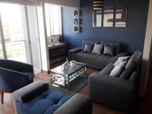 Sala de estar con 2 sofás y mesa de centro en Miraflores Heart Apartment, en Lima