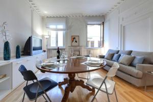 佛羅倫斯的住宿－Finardi Apartment，客厅配有桌子和沙发