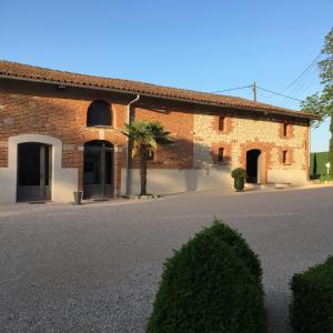 a brick building with a palm tree in front of it at Domaine de Gailhaguet B&B in Verfeil