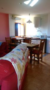 a room with a table and chairs and a kitchen at Apartamentos La Panerona in Tineo