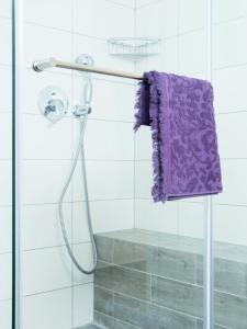 a shower with a purple towel hanging on a pole at Nitza Boutique Apartment Kosher in Netanya