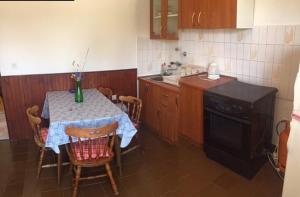 eine Küche mit einem Tisch und einem Tisch und Stühlen in der Unterkunft Apartments Bili in Starigrad-Paklenica
