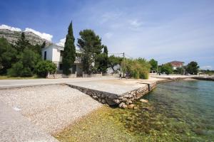 eine steinerne Wand neben einem Wasserkörper in der Unterkunft Apartments Bili in Starigrad-Paklenica