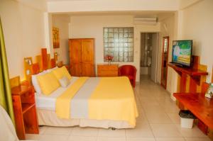 a bedroom with a bed with a yellow and gray blanket at The Champs in Portsmouth