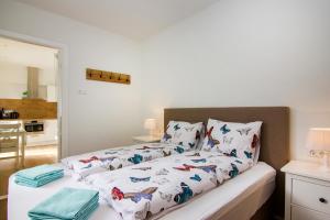 a bedroom with a bed with white sheets with butterflies at Lou-Lou in Zandvoort