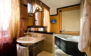 a bathroom with a sink and a bath tub at Grand Hotel Savoia in Genoa