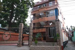 a building with a wrought iron gate and a fence at Little Rangpur Inn in Rangpur