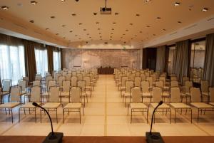 a large room with chairs and a stage in the middle at Grand Hotel Savoia in Genoa