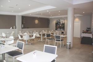 a dining room with white tables and chairs at Hotel Puerta del Mar - Adults Recommended in Nerja
