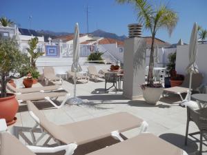 a group of chairs and tables on a patio at Hotel Puerta del Mar - Adults Recommended in Nerja