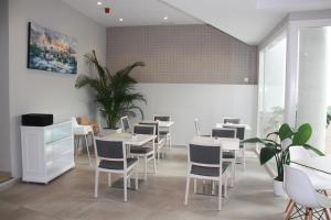 a dining room with white tables and chairs at Hotel Puerta del Mar - Adults Recommended in Nerja