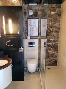 カップ・ダグドにあるCap d'Agde Naturist Apartmentsのバスルーム(トイレ、ガラス張りのシャワー付)