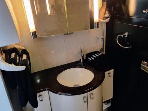 La salle de bains est pourvue de toilettes et d'un comptoir noir. dans l'établissement Cap d'Agde Naturist Apartments, au Cap d'Agde