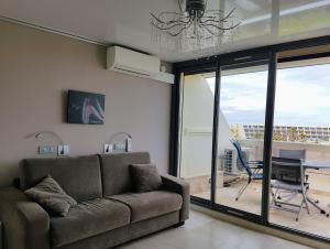 een woonkamer met een bank en een eettafel bij Cap d'Agde Naturist Apartments in Cap d'Agde