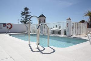 a swimming pool with metal hand rails next to it at Hotel Puerta del Mar - Adults Recommended in Nerja