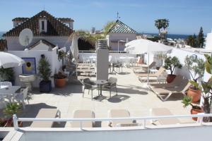 a patio with chairs and umbrellas on a building at Hotel Puerta del Mar - Adults Recommended in Nerja