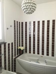 a bathroom with a large tub and a chandelier at Villa Manu in Massa Lubrense