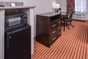 a kitchen with a microwave and a desk with a table at Americas Best Value Inn & Suites Bastrop in Bastrop