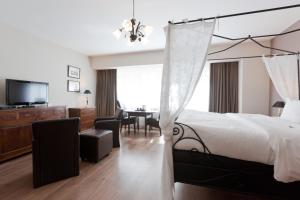 um quarto com uma cama e uma sala de jantar em Hotel De Hofkamers em Oostende