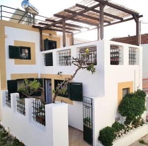 a house with white walls and a black door at Villa Smaragdi-Despoina in Malona Village