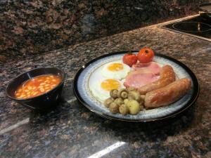 a plate of breakfast food with eggs sausage and beans at The Hollies on the Wall in Gilsland