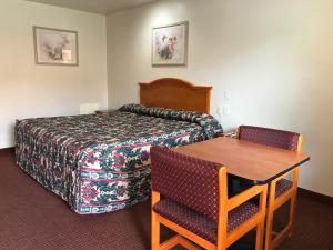 um quarto de hotel com uma cama, uma mesa e cadeiras em Nogalitos Motel em San Antonio