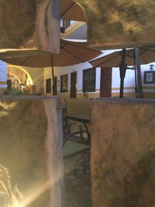 a patio with an umbrella and a table and chairs at Hotel San Miguel Arcangel in Izamal +45 photos