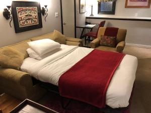 a bedroom with a bed and a couch and chairs at Barclay House Bed and Breakfast in Vancouver