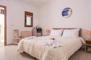 a bedroom with a large bed with towels on it at Smaragdi in Perivolos