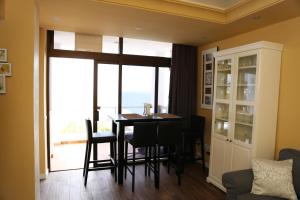 ein Esszimmer mit Tisch und Stühlen und einem großen Fenster in der Unterkunft Avenida de la Cornisa 11 in Puerto Rico de Gran Canaria