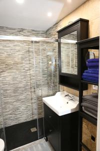 ein Badezimmer mit Dusche, Waschbecken und Spiegel in der Unterkunft Avenida de la Cornisa 11 in Puerto Rico de Gran Canaria + 16 Fotos