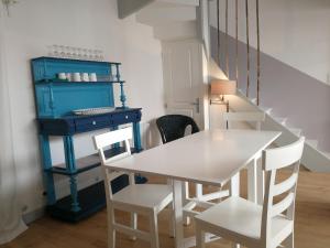 a dining room with a table and chairs and a desk at Un jardin sur le toit - Saintes in Saintes