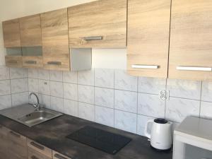 a kitchen with wooden cabinets and a sink at Pokoje Gościnne Wiola in Władysławowo +64 photos