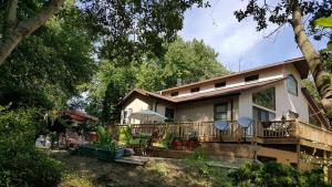 a large house with a deck and trees at Tortuga Inn in Winamac