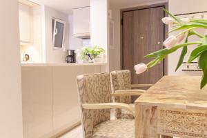 Sweet Suite Flora in Vouliagmeni في أثينا: مطبخ مع طاولة وكراسي خشبية