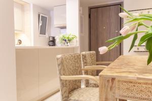 cocina con mesa de madera y sillas en Sweet Suite Flora in Vouliagmeni, en Atenas