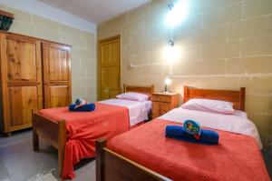 ein Schlafzimmer mit 2 Betten und blauen Handtüchern darauf in der Unterkunft Kaccatur Flats in Marsalforn