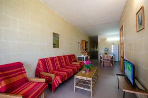 un soggiorno con un divano rosso e un tavolo di Kaccatur Flats a Marsalforn